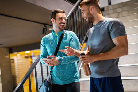 Happy friends enjoying break while chatting in the gym