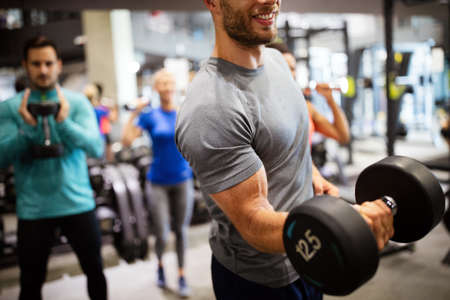 Group of young happy fit people doing exercises in gymの写真素材