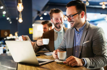 Happy young attractive business man friends talking in cafe urbanの写真素材