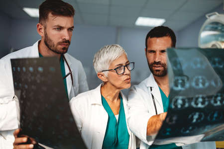 Group of doctors examining an x-ray in hospital to make diagnosis