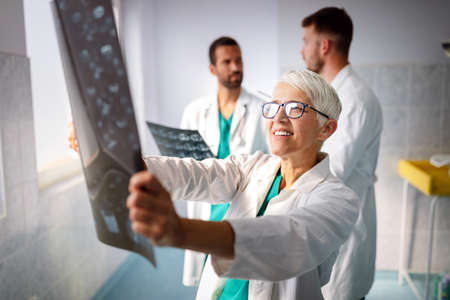 Group of doctors examining an x-ray in hospital to make diagnosisの写真素材