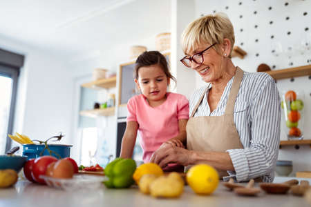 Grandmother and granddaughter are cooking on kitchen. Family fun love generation conceptの写真素材