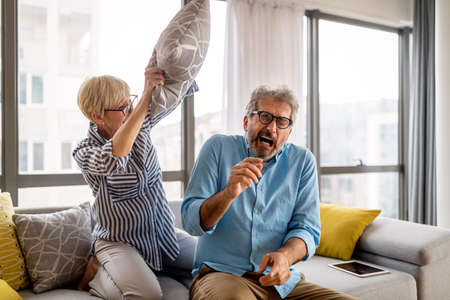 Family quarrel. Upset, scared senior man against angry woman at home