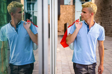 Handsome attractive man smiling shopping in the city