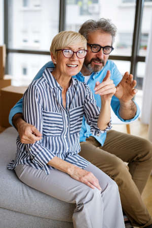 Happy senior couple in love hugging and bonding with true emotions at homeの写真素材