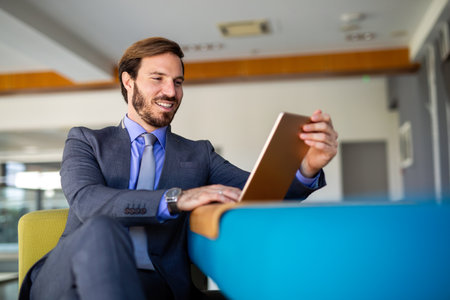Portrait of young businessman with digital tablet in officeの写真素材