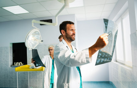 Medical team doctors checking on X-ray results in hospitalの写真素材