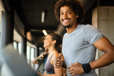 Group of young people running on treadmills in sport gymの写真素材