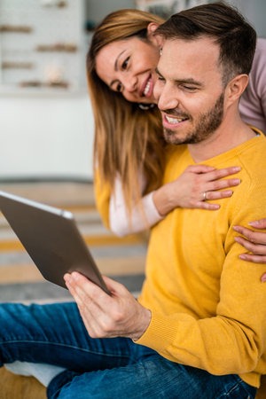 Young couple in love at home websurfing on internetの写真素材