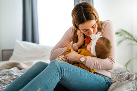 Mother and baby daughter plays, hugging, kissing at home. Happy family.の写真素材