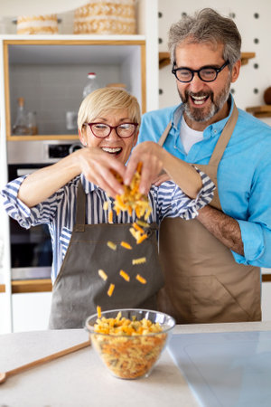 Happy senior couple cooking together and having fun in home kitchenの写真素材
