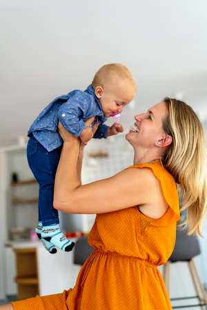 Happy mother with adorable girl toddler at homeの写真素材