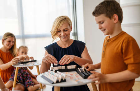 Children and woman learn while playing a board game. Education, fun, children conceptの写真素材