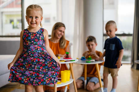 Family, children, education, happiness concept. Mother teaches preschooler kids to do craft items.の写真素材