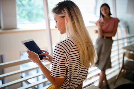 Portrait of pretty student or businesswoman in smart casual using digital tablet