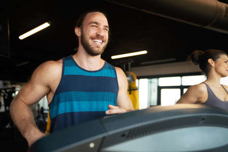 Group of young people running on treadmills in sport gymの写真素材