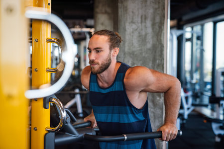 Fit man exercising at the gym on a machineの写真素材