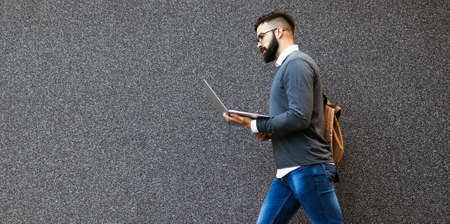 Handsome confident man using laptop computer outdoor