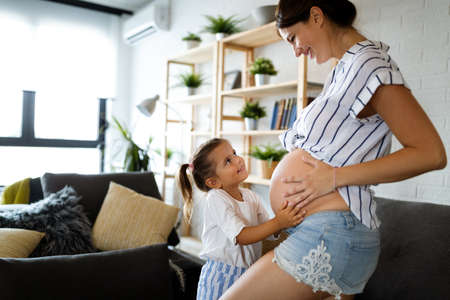 Happy family, togetherness, love. Beautiful pregnant mother with cute childの写真素材