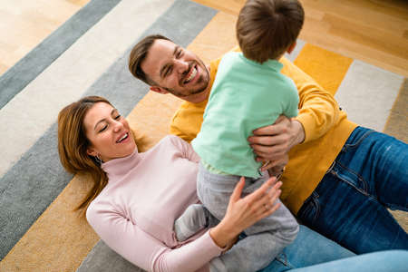 Happy young family having fun times and playing together at home