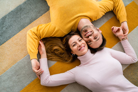 Happy couple in love hugging and enjoying time together at homeの写真素材