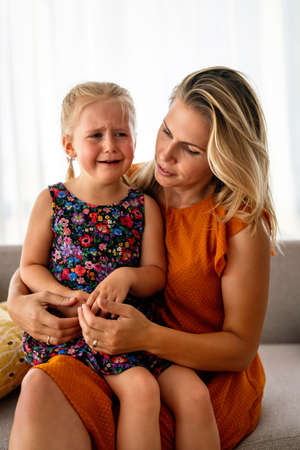 Mother comforting her crying little girl. Parenthood, family support concept