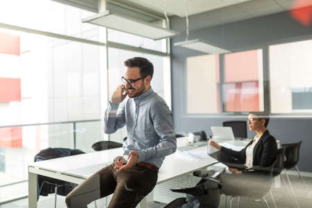 Handsome successful businessman on a phone in the office.の写真素材