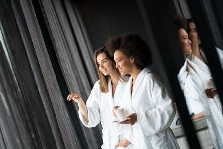 Attractive happy young women drinking coffee at spa centerの写真素材