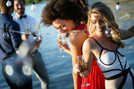 Group of beautiful people friends celebrating, dancing and having fun together outdoorの写真素材