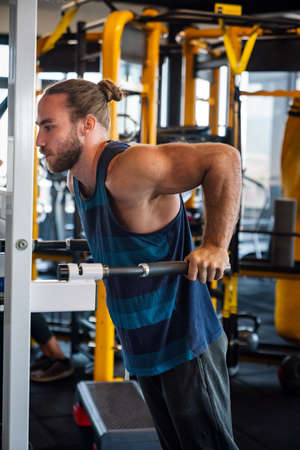 Young muscular man during workout in the gym