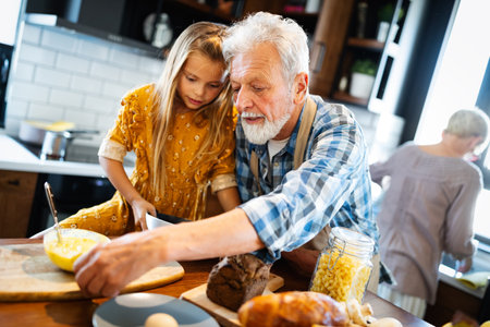 Smiling grandparents having breakfast with their granddaughterの写真素材
