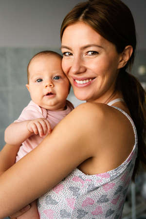 Happy cheerful family. Mother and baby kissing, laughing and huggingの写真素材