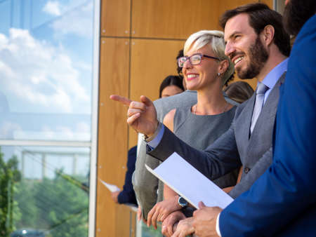 Successful business people are talking and smiling during the coffee break in office outdoor