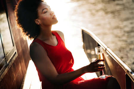 Summer lifestyle fashion portrait of stylish black woman with drinkの写真素材