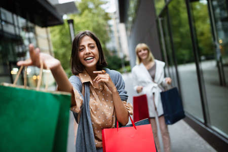 Shopping and tourism concept. Beautiful women with shopping bags in ctiy having funの写真素材