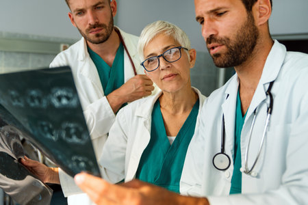 Radiologist doctor consulting with colleagues an x-ray scan in hospital.の写真素材