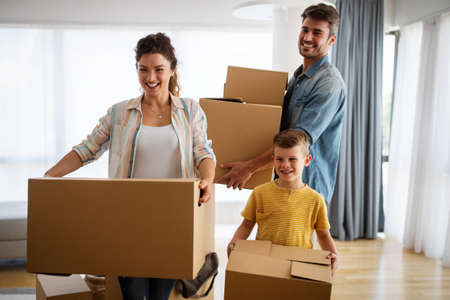 Family unpacking cardboard boxes at new homeの写真素材