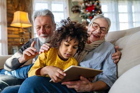 Portrait of happy grandparents with child playing together at homeの写真素材