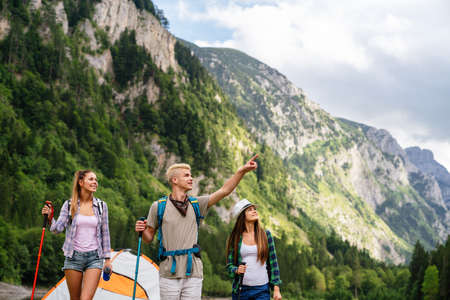 Group of friends with backpacks doing trekking excursion on mountainの写真素材