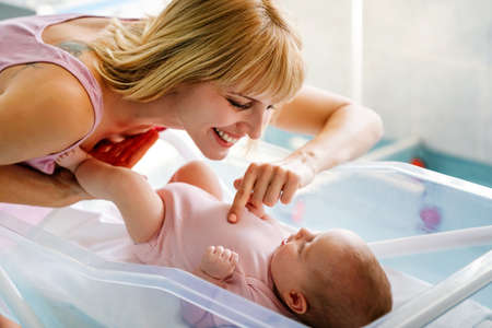 Happy cheerful family. Mother and baby kissing, laughing and huggingの写真素材