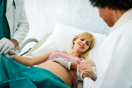 Woman giving birth in hospital with medical doctor team
