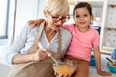 Grandmother and granddaughter are cooking on kitchen. Family fun love generation conceptの写真素材