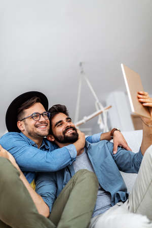 Homosexual couple enjoying video chat using digital tablet at homeの写真素材