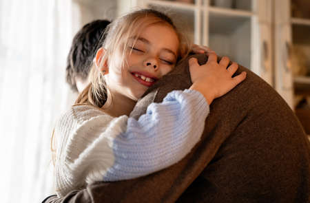 Happy family and fathers day. Father and his daughter hugging and having fun togetherの写真素材