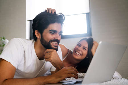 Romantic happy couple in love relaxing at home having fun. People technology concept.の写真素材