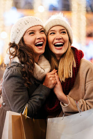 Sale, shopping, tourism and happy people concept. Beautiful females with shopping bags in the cityの写真素材