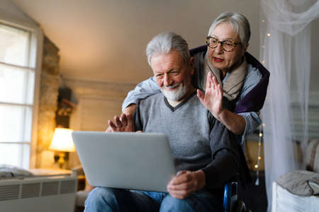 Happy senior couple using notebook at home and having fun together. Technology people conceptの写真素材