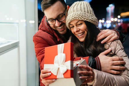 Young couple in love is celebrating with gift. Christmas birthday valentines day present conceptの写真素材