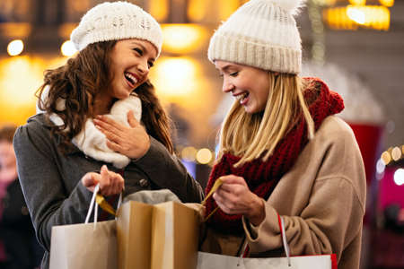 Happy women friends are shopping for presents at Christmas. People holiday sale shopping conceptの写真素材