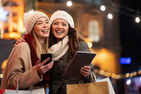 Women friends enjoy the night in shopping at Christmas. Sale, people digital tablet conceptの写真素材